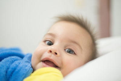 Portrait of cute baby lying on bed