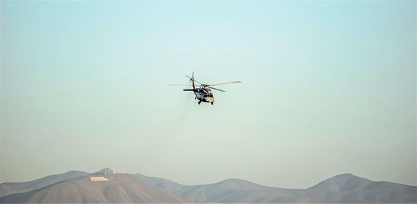 Low angle view of helicopter flying against clear sky