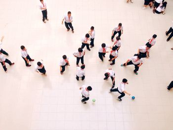 High angle view of students playing on tiled floor