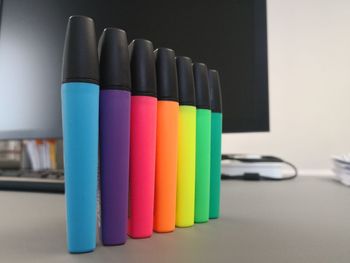 Close-up of multi colored highlighters on desk in office