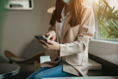 Midsection of woman using mobile phone