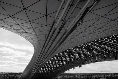 Low angle view of bridge against cloudy sky