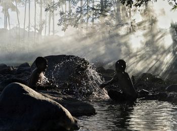 People on river amidst trees