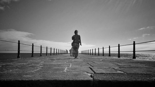 Full length of woman standing against sky