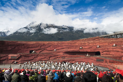 Group of people on snowcapped mountain against sky