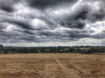 Scenic view of field against cloudy sky