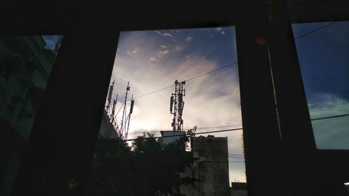 Low angle view of silhouette buildings against sky