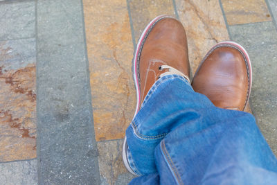 Low section of man standing on cobblestone