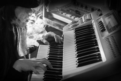 Close-up of woman exhaling smoke while playing piano