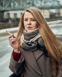 Portrait of woman with cigarette in winter