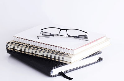 High angle view of eyeglasses on table against white background