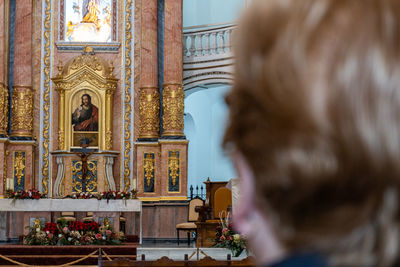 Unrecognizable woman from behind and out of focus, in a catholic church.