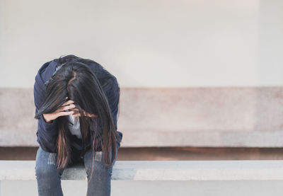 Midsection of woman standing against wall