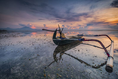 Boat in sea against sky during sunset