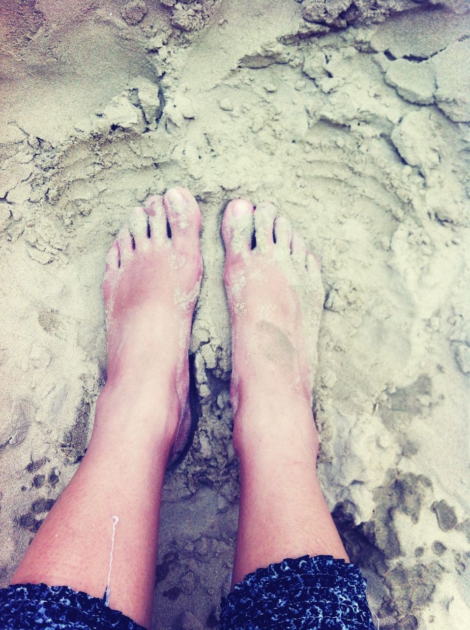 low section, person, beach, lifestyles, personal perspective, leisure activity, barefoot, sand, human foot, standing, vacations, high angle view, water, shore, rock - object, outdoors