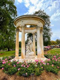 Statue in park against cloudy sky