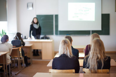 Rear view of students sitting in classroom