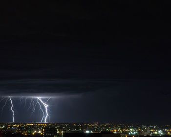 Aerial view of illuminated city against sky at night