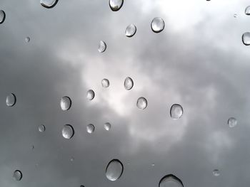 Full frame shot of wet bubbles against sky during rainy season