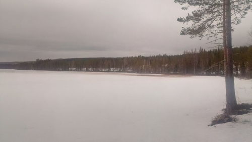 Scenic view of snow covered land against sky