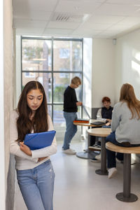 Group of friends and lone girl on school corridor