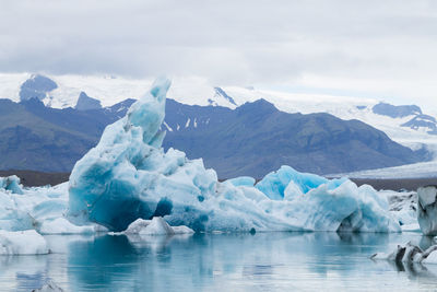 Frozen lake against mountain range