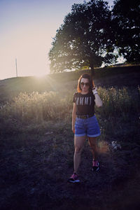 Full length of woman standing on field against sky