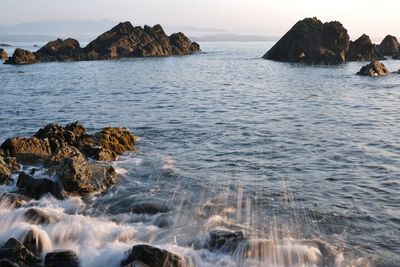 Scenic view of rocks in sea against sky