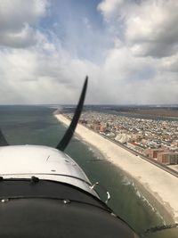 Airplane flying over sea against sky