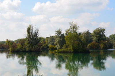 Scenic view of lake by trees against sky