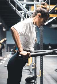 Side view of female athlete exercising in gym