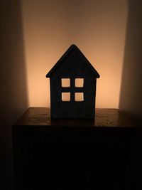 Illuminated house against sky at sunset
