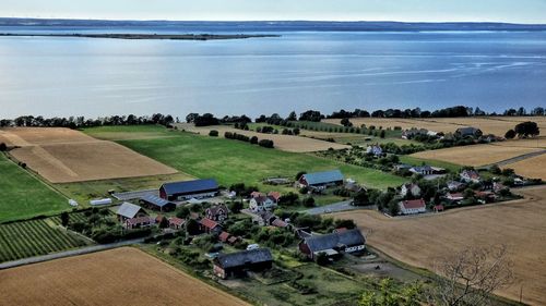 High angle view of houses on agricultural field by sea