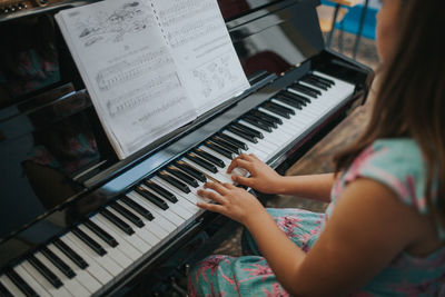 Midsection of woman playing piano