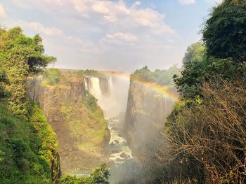 Scenic view of waterfall against sky