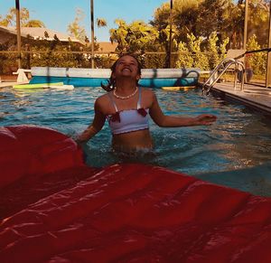 Smiling young woman swimming in pool