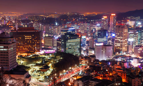 High angle view of city lit up at night