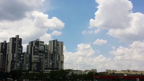 Buildings in city against cloudy sky