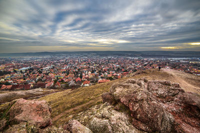 Aerial view of cityscape against cloudy sky