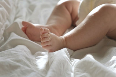 Baby legs close up on white blanket. newborn feet. warm sunlight. infant. authentic candid lifestyle