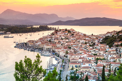 High angle view of town by river at sunset