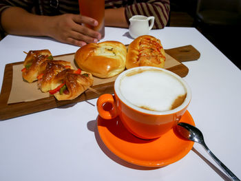 Close-up of hand holding coffee cup on table