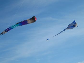 Low angle view of kites flying against sky