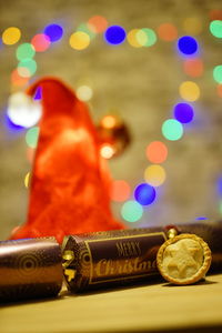 Close-up of cookie and gifts on table against defocused lights at night