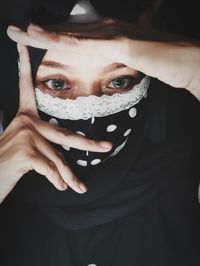 Close-up portrait of woman covering face