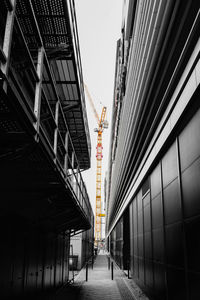 Low angle view of a crane between buildings
