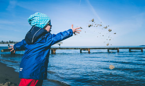 Child on beach against blue sky