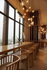 Illuminated pendant lights hanging on glass window at home