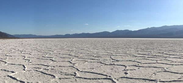 Scenic view of salt flat against sky