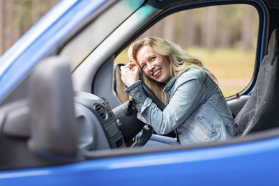 Portrait of smiling woman sitting in car